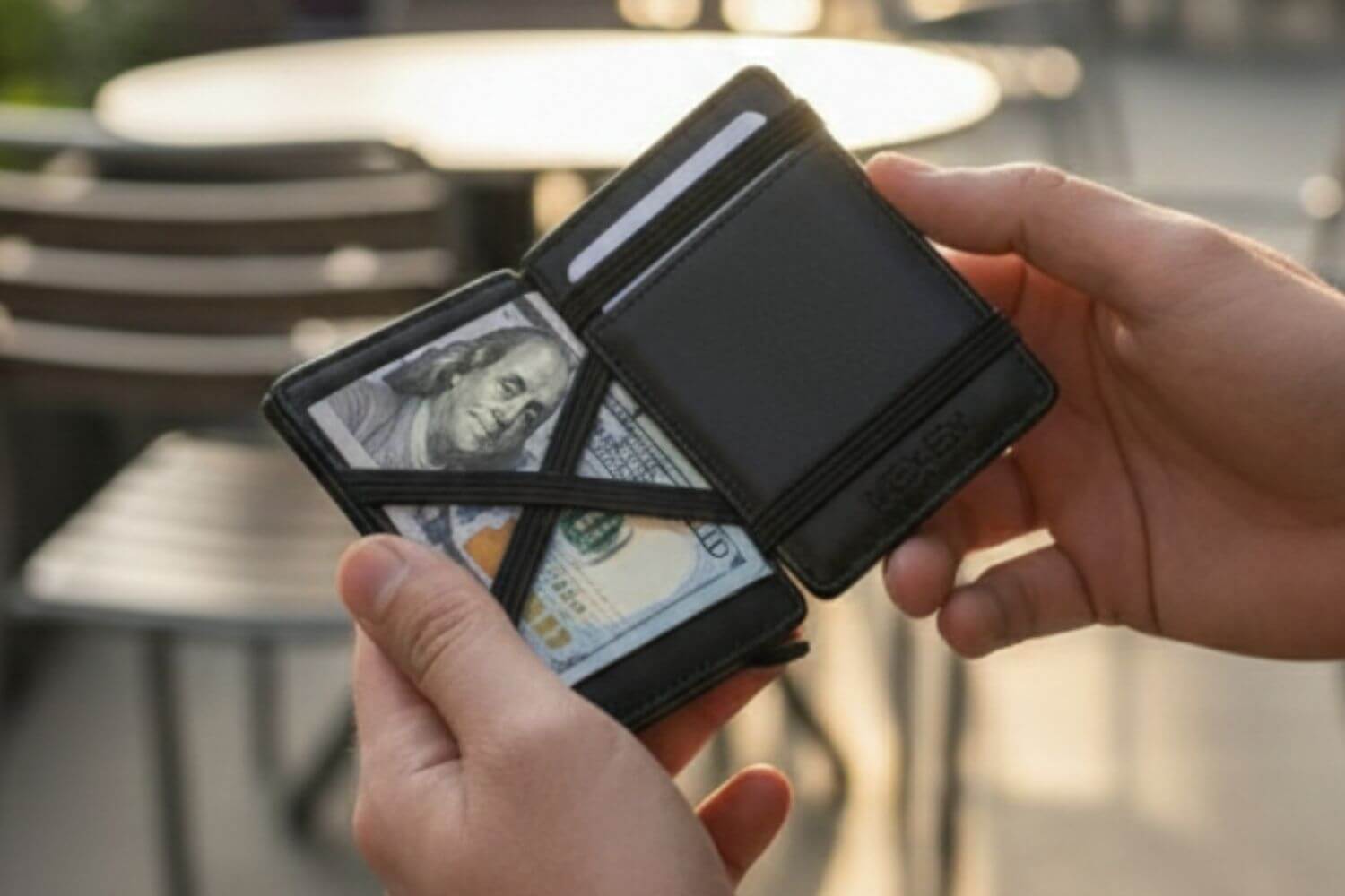 Person holding the Wexler Magic Wallet with cash and cards, showcasing its slim everyday carry design.